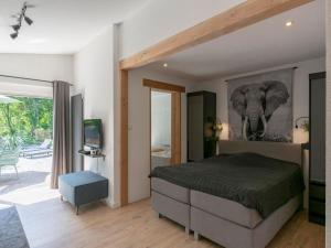 a bedroom with a bed with an elephant picture on the wall at De Blenck 29 Bungalow near dunes, beach in Callantsoog