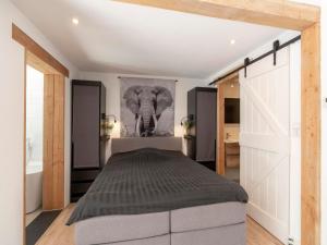a bedroom with a bed and a painting of an elephant at Bungalow in Callantsoog near the Beach in Callantsoog