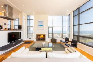 a living room with white furniture and a fireplace at Stunning Panoramic Ocean Views Penthouse Hot Tub in Manhattan Beach