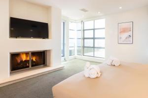 a bedroom with a fireplace and two stuffed animals on a bed at Stunning Panoramic Ocean Views Penthouse Hot Tub in Manhattan Beach +57 photos