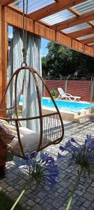 a swinging chair on a patio next to a pool at Casa Olivia- Alojamiento con piscina - Aeropuerto Ezeiza in Ezeiza