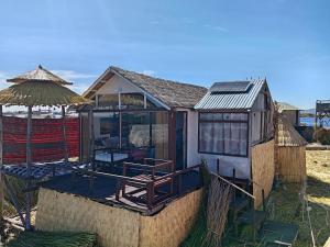 a small house with a table and an umbrella at TITIKAKA chakana lodge in Puno
