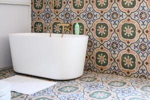 a bathroom with a white tub in front of a wall at Checz Swornegacie - Dom wakacyjny nad jeziorem Karsińskim in Swornegacie  +63 photos