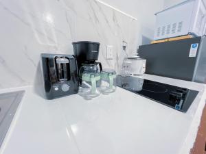 eine Theke mit Kaffeemaschine und zwei Gläsern darauf in der Unterkunft Forest apartments studio F1, walking to the beach in Jacó