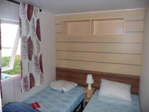 a small bedroom with two beds and a window at Mobil Home in Saint-Jean-de-Monts