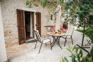 a patio with a table and chairs in front of a building at Rural Apartments Ritossa in Vižinada
