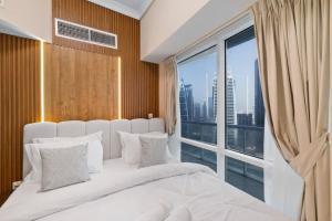 a bedroom with a large white bed with a large window at Elegant Haven and Spacious 2BR in Lake Terrace in Dubai +48 photos