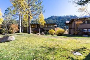 ein Haus auf einem Hügel mit einem Rasenplatz in der Unterkunft Serene Condo by Palisades Base and Golf Course in Olympic Valley