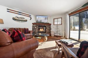 ein Wohnzimmer mit Sofa und Kamin in der Unterkunft Serene Condo by Palisades Base and Golf Course in Olympic Valley