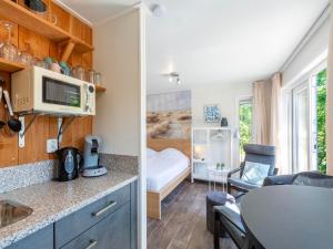 a small room with a kitchen and a bedroom at Chalet in Texel near Beach and Forest in Sint Maartenszee +22 photos