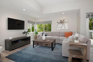 een woonkamer met een bank en een tv bij Chic Upstairs Condo Steps from Strands Beach in Dana Point