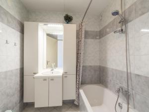 Un baño blanco con lavabo y ducha. en Apartment by Dunes with Balcony Views, en Julianadorp 36 fotos más