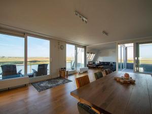 a large living room with a table and chairs at Penthouse Duinerei by the sea with sauna in Callantsoog