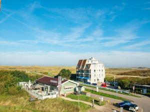 a large white building in the middle of a road at Penthouse Duinerei by the sea with sauna in Callantsoog