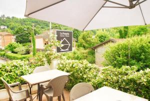 a patio with tables and chairs and an umbrella at La Pergola with Private Parking in Vezzano Ligure