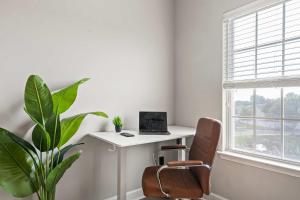 - un bureau blanc avec un ordinateur portable installé à côté d'une usine dans l'établissement Upscale King 3BR Townhouse in Pineville, à Charlotte