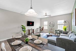un salon avec un canapé, une table et des chaises dans l'établissement Upscale King 3BR Townhouse in Pineville, à Charlotte