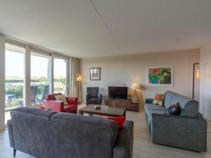 Una sala de estar con dos sofás y un televisor. en Apartment in Groote Keeten near Sandy Beach, en Callantsoog