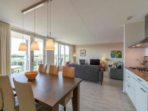Una cocina y una sala de estar con mesa y sillas. en Apartment in Groote Keeten near Sandy Beach, en Callantsoog