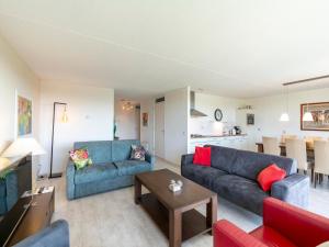 Una sala de estar con dos sofás azules y una mesa. en Apartment in Groote Keeten near Sandy Beach, en Callantsoog 11 fotos más