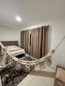 a hammock in a room with a bed at Cantinho Serrano in Serra de São Bento