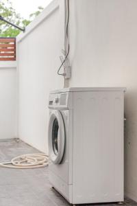 a washing machine sitting next to a wall at Auqa Pool Villa by DRH in Ban Bung