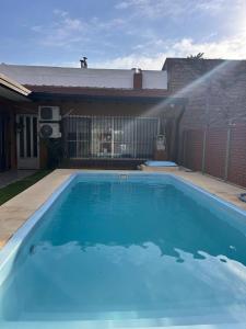 a large blue swimming pool in front of a house at Casa Olivia- Alojamiento con piscina - Aeropuerto Ezeiza in Ezeiza