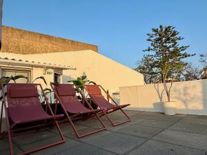deux chaises assises sur une terrasse devant un bâtiment dans l'établissement Casa Sebastião, à Faro