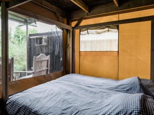 een bed in een kamer met een raam bij Charming Woodlodge Stay in Callantsoog