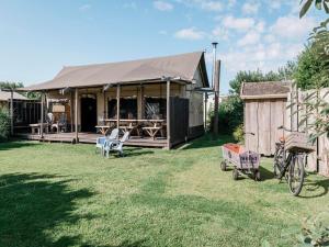 een gebouw met een tent in een tuin bij Charming Woodlodge Stay in Callantsoog +19 foto's