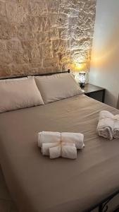 un letto con due asciugamani arrotolati sopra di Mary Home a Martina Franca