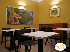 a waiting room with tables and chairs and a painting on the wall at Casa e Putiga in Castiglione Cosentino
