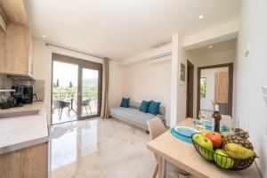 a kitchen and living room with a table with a bowl of fruit at Maera Apartments in Sami