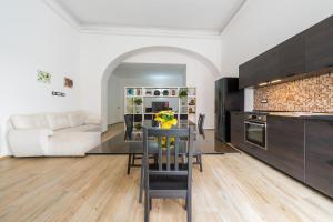 a kitchen and living room with a table and a couch at Loft Eleonora D’Arborea in Quartu SantʼElena
