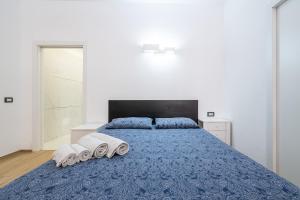 a bedroom with a blue bed with two towels on it at Loft Eleonora D’Arborea in Quartu SantʼElena
