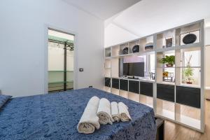 a bedroom with a blue bed with towels on it at Loft Eleonora D’Arborea in Quartu SantʼElena
