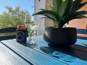 a table with a glass of wine and a potted plant at Sojourn Sanctuary Seaside Escape 3 BR in Virginia Beach