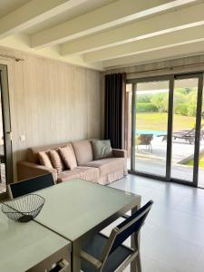 a living room with a couch and a table at Apartments PETIT DOMAIN DE SPERONE in Bonifacio +3 photos