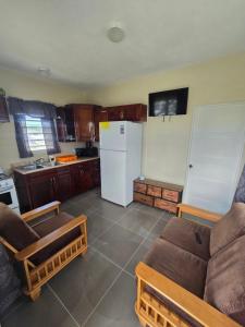 a kitchen with a couch and a white refrigerator at Tiny Bliss Apartments in Potters Village +13 photos