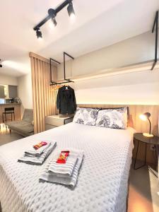 a bedroom with a bed with towels on it at Studio Moderno 401 Santa Casa UFRGS Estacionamento grátis in Porto Alegre