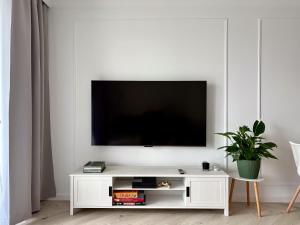 a living room with a white entertainment center with a flat screen tv at Luksusowy Apartament Onyks - Parking Gratis in Suwałki