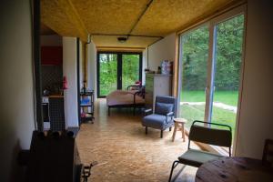 a living room with chairs and a bed and windows at Na Palouku in Horní Cerekev