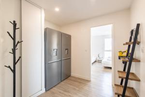 a kitchen with a stainless steel refrigerator in a room at Large 4 Bedroom Apartment near metro - only 30 minutes to Paris and Disneyland in Créteil