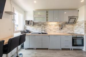 a kitchen with white cabinets and a sink at Large 4 Bedroom Apartment near metro - only 30 minutes to Paris and Disneyland in Créteil +40 photos