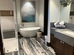 a bathroom with a bath tub and a sink at Exclusive Villa with Expansive Space & Private Bar in Foxfield +63 photos