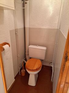 a bathroom with a toilet with a wooden toilet seat at Logement 48m2- 2 chambres in Orcières +10 photos