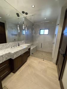 a large bathroom with two sinks and a shower at Exclusive Villa with Expansive Space & Private Bar in Foxfield