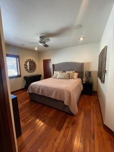 a bedroom with a bed and wooden floors at Exclusive Villa with Expansive Space & Private Bar in Foxfield