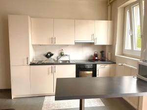 a kitchen with white cabinets and a sink at Fully Furnished down town- 5 minutes from Lausanne Train station in Lausanne