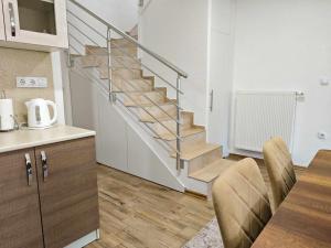 a kitchen with a staircase and a table with chairs at Villa Pliva Lake 2 in Jajce